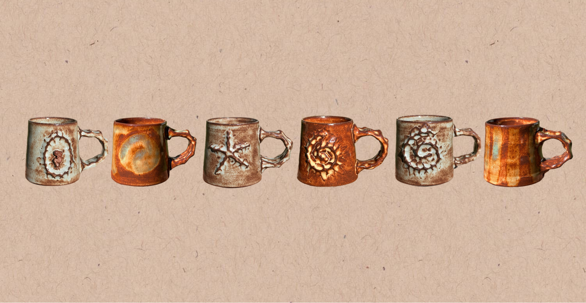 Set of six ceramic mugs with decorative designs on a beige background